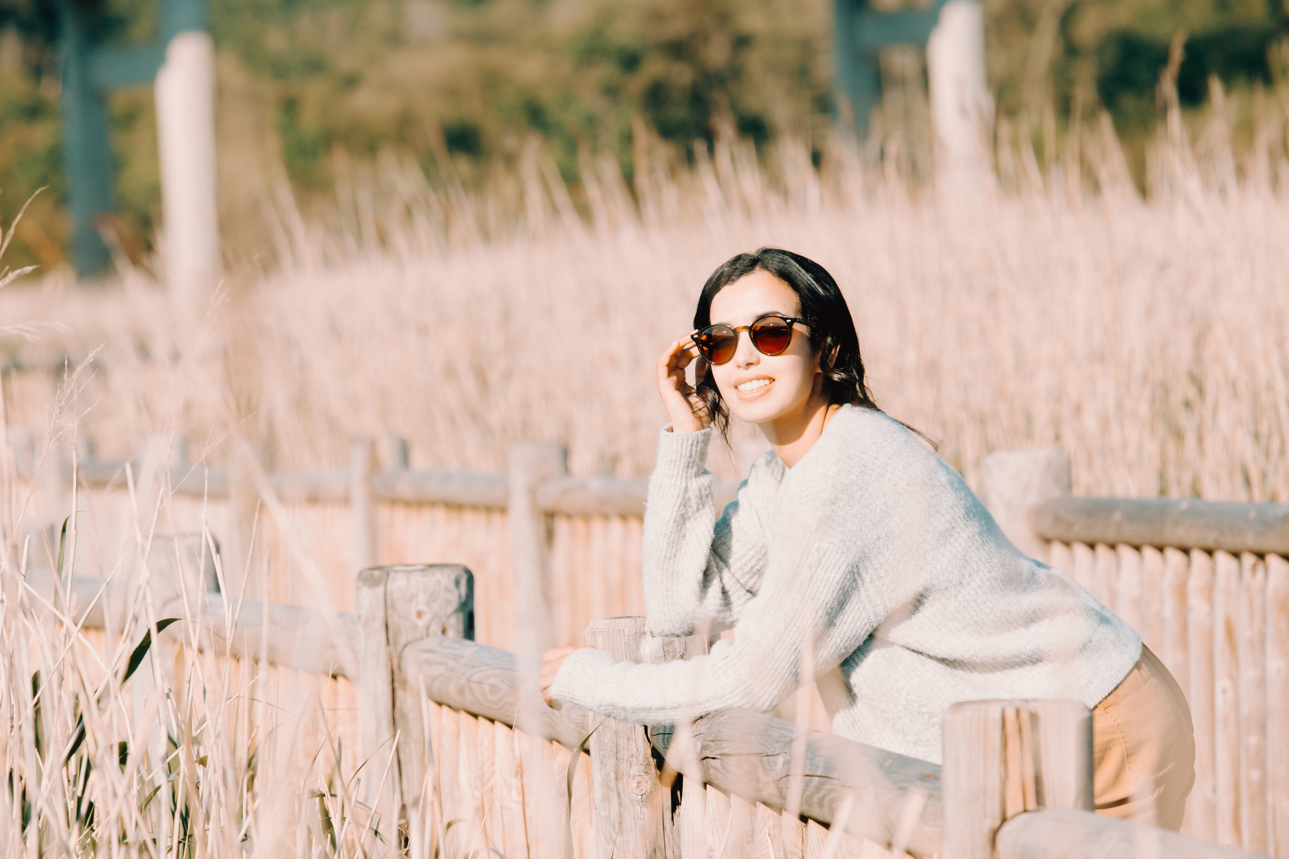 files/woman-in-sunglasses-leans-on-a-wooden-fence.jpg
